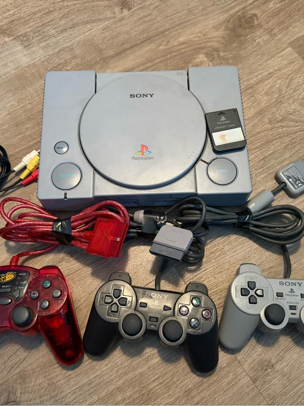 Sony PlayStation Console with Gray, Black & Red Controllers